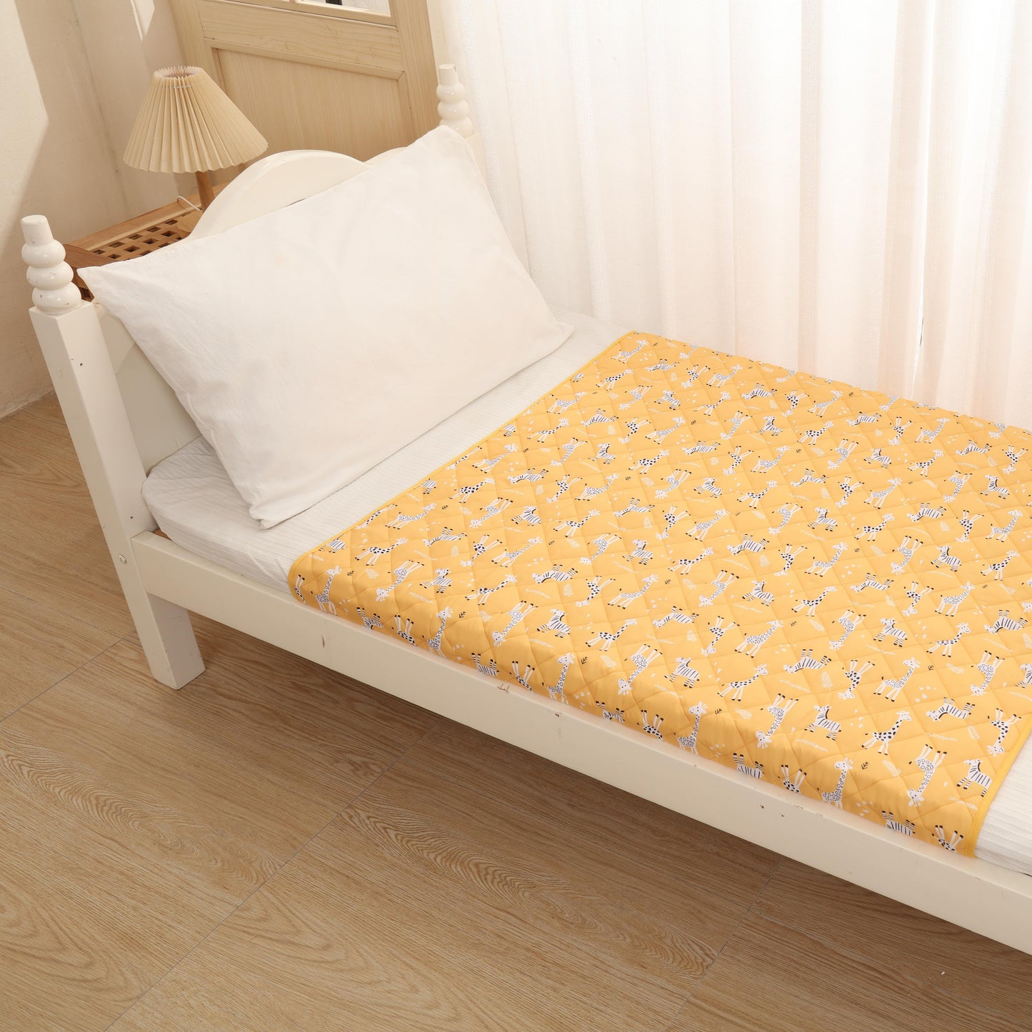 Yellow floral-patterned mattress cover on a white bed with white pillows.