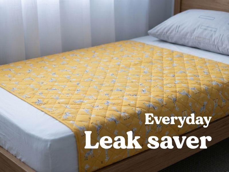 Bed guard installed under fitted sheet for safe night transition